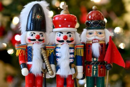 a group of nutcrackers standing next to a christmas tree